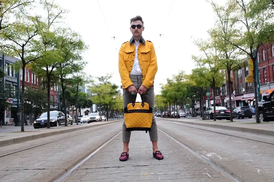 Man in yellow jacket holds matching yellow bag