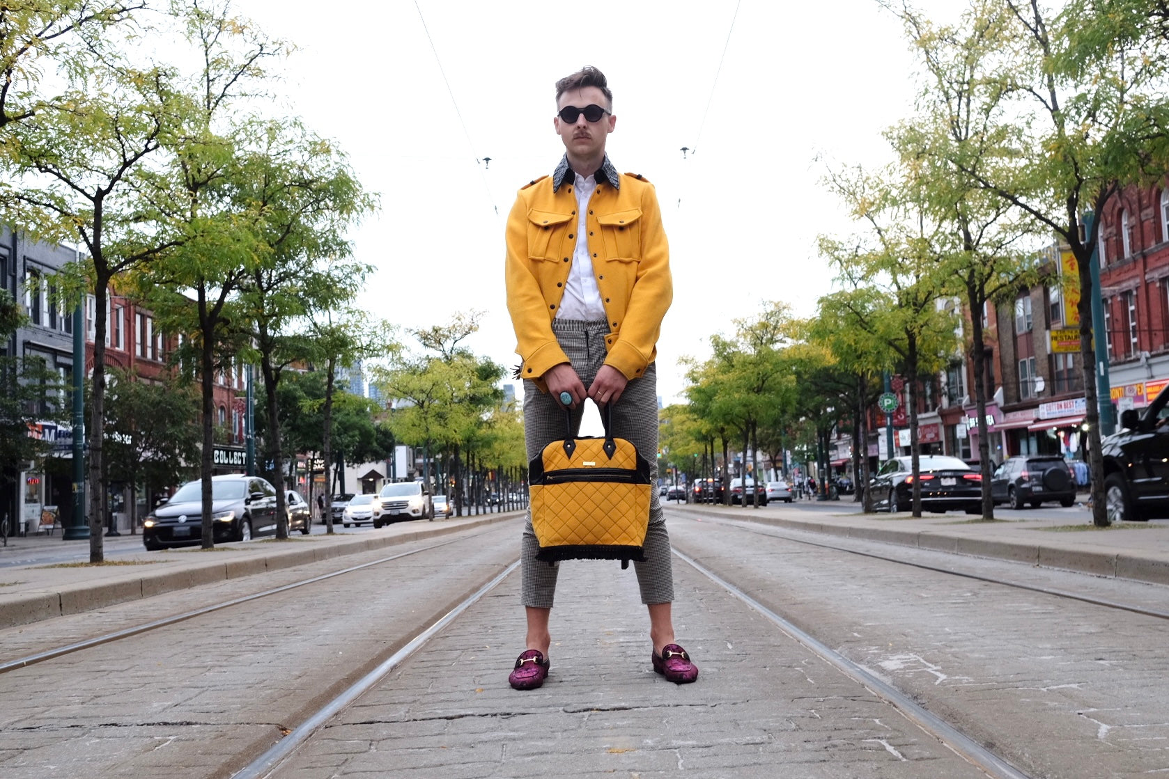 Male model in yellow jacket holds Hart & Hive yellow tote bag